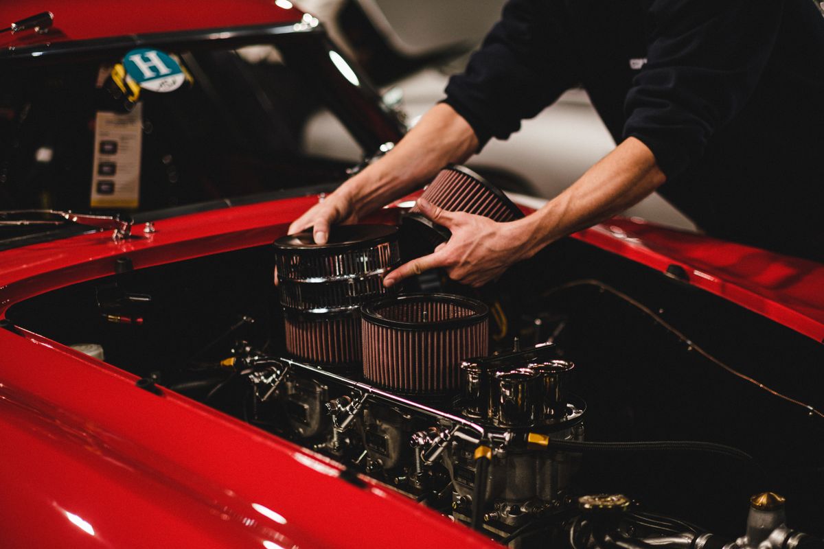 Mecánico instalando filtros de aire en el motor de un coche clásico